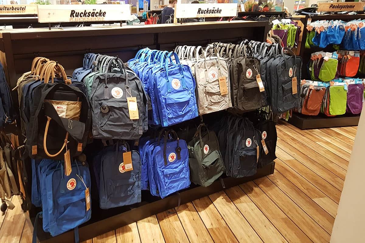 A rack of travel backpacks for sale in an outdoor shop