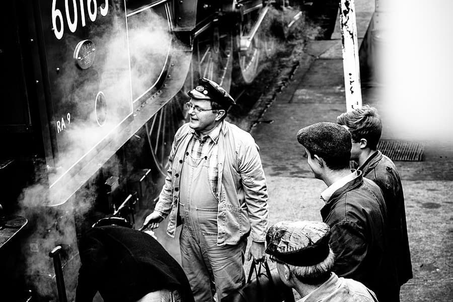 Travelers with luggage beside a train