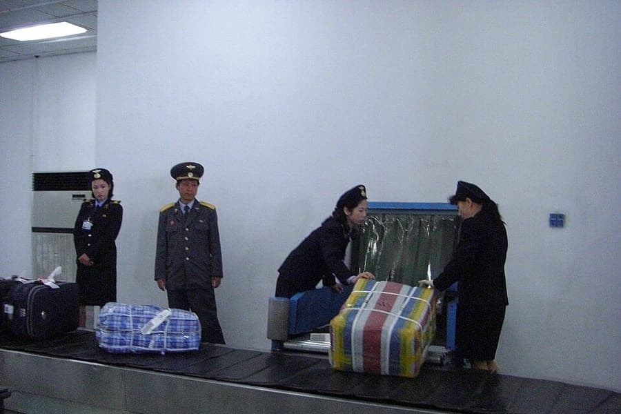 Checked suitcases moving along an airport baggage belt