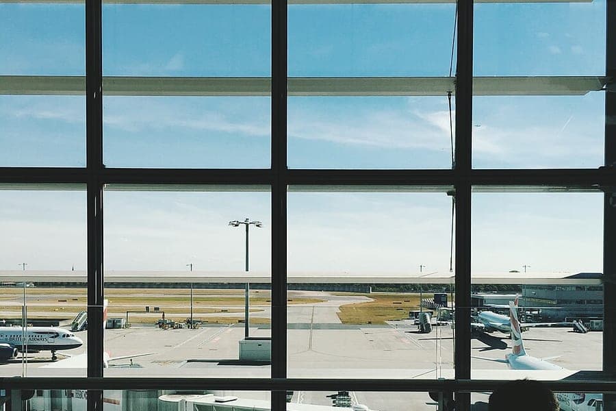 People watching aircraft from an airport window