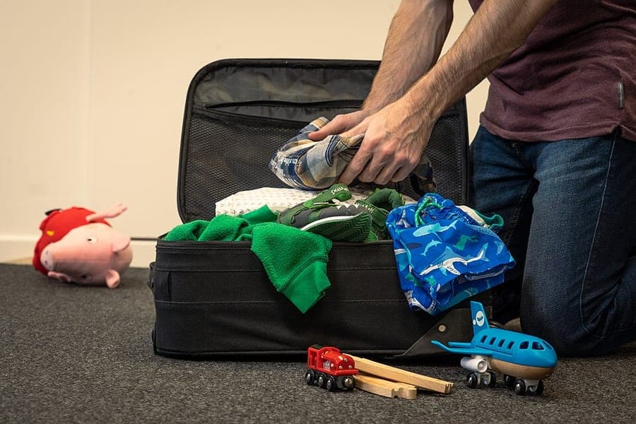 Family holiday packing laid out on a bed