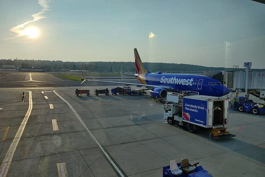 Bags waiting beside an aircraft at a jet bridge