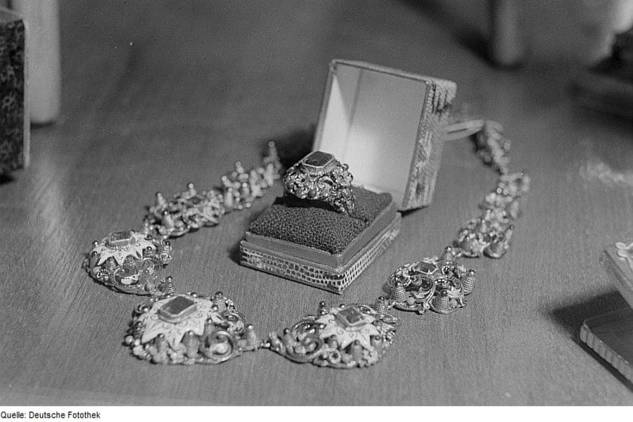 A ring displayed in a case beside a necklace