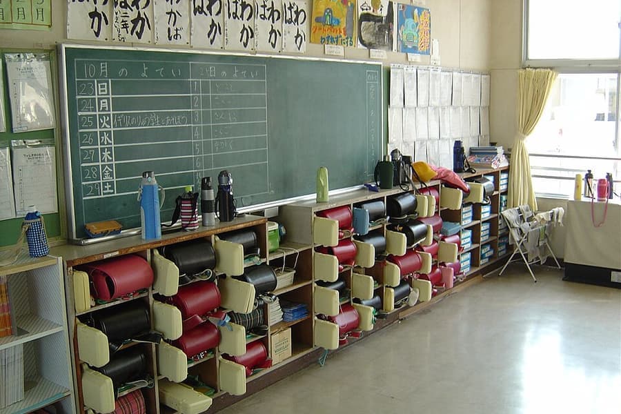 A classroom with school backpacks hanging on the wall