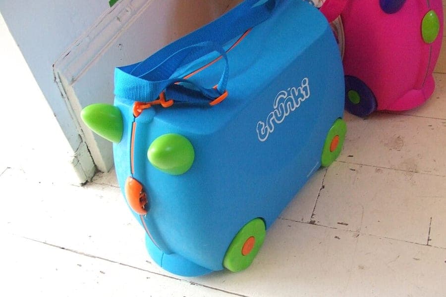 Two brightly colored ride-on children's suitcases