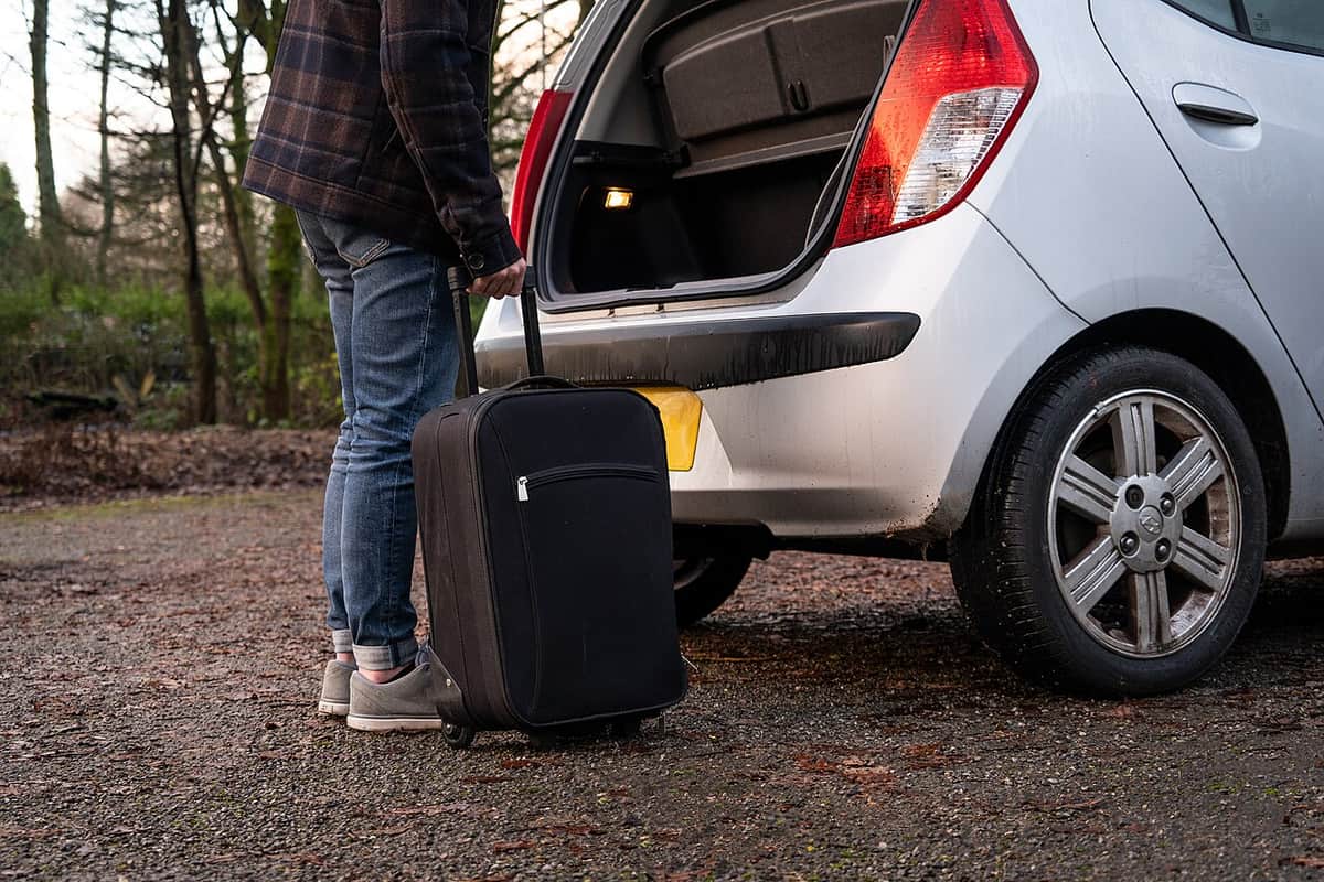 Suitcases being loaded into the back of a car