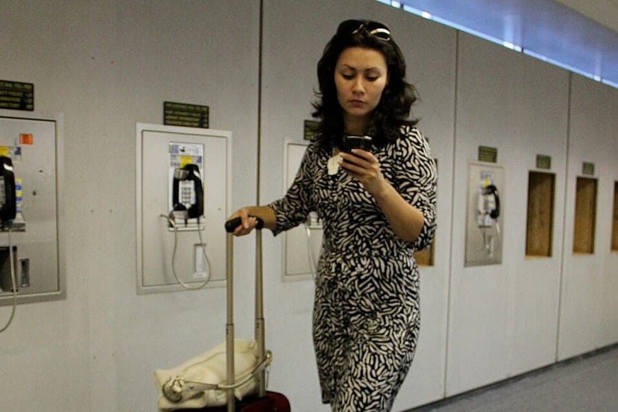 A person standing with a suitcase