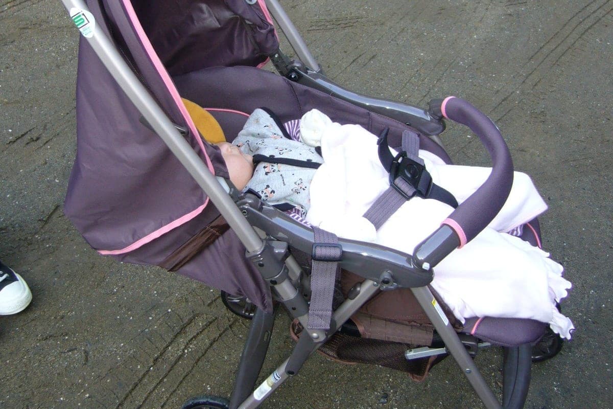 A folding baby stroller parked on a pavement