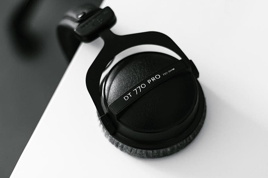 Over-ear headphones hanging from the edge of a desk