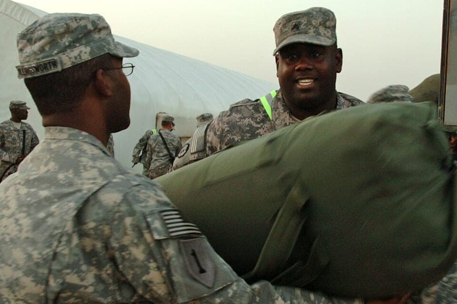 Duffel bags being unloaded from a vehicle
