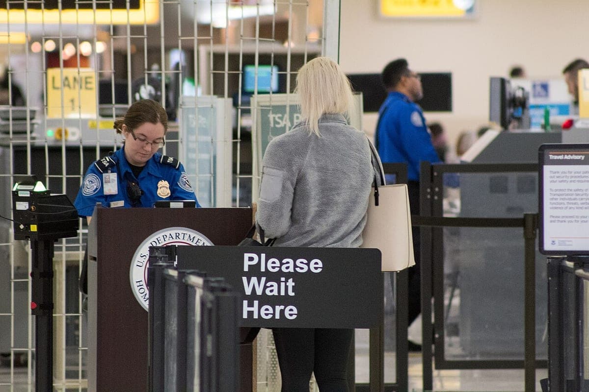 A TSA officer checking documents at an airport security checkpoint