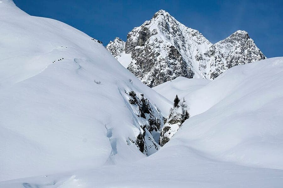 Skiers on a groomed resort piste