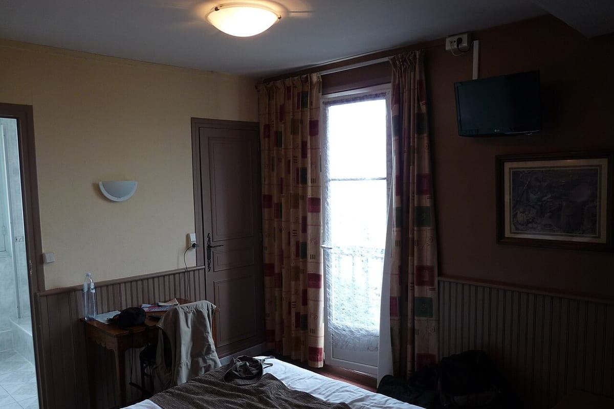 A quiet hotel room with a bed and a window