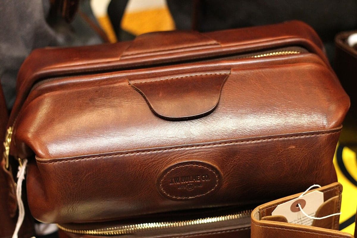 A leather dopp kit toiletry bag open on a table