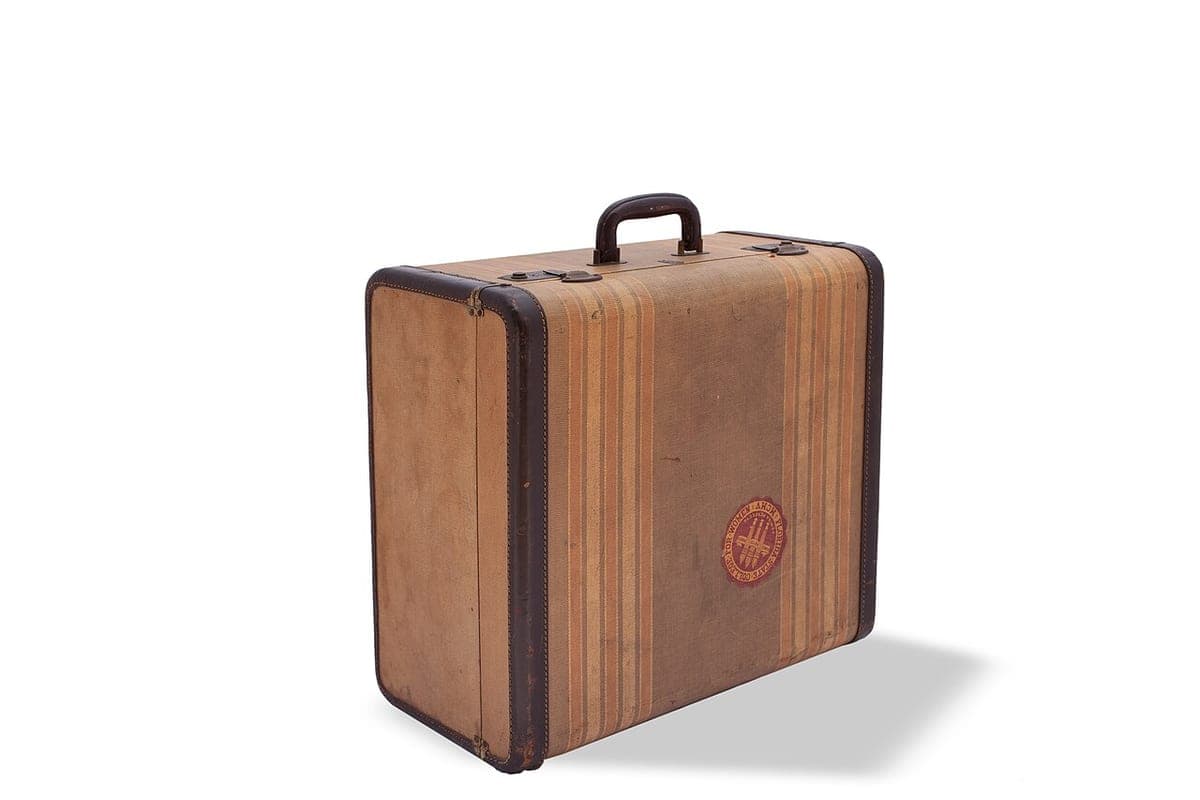 A small vintage suitcase photographed against a plain background