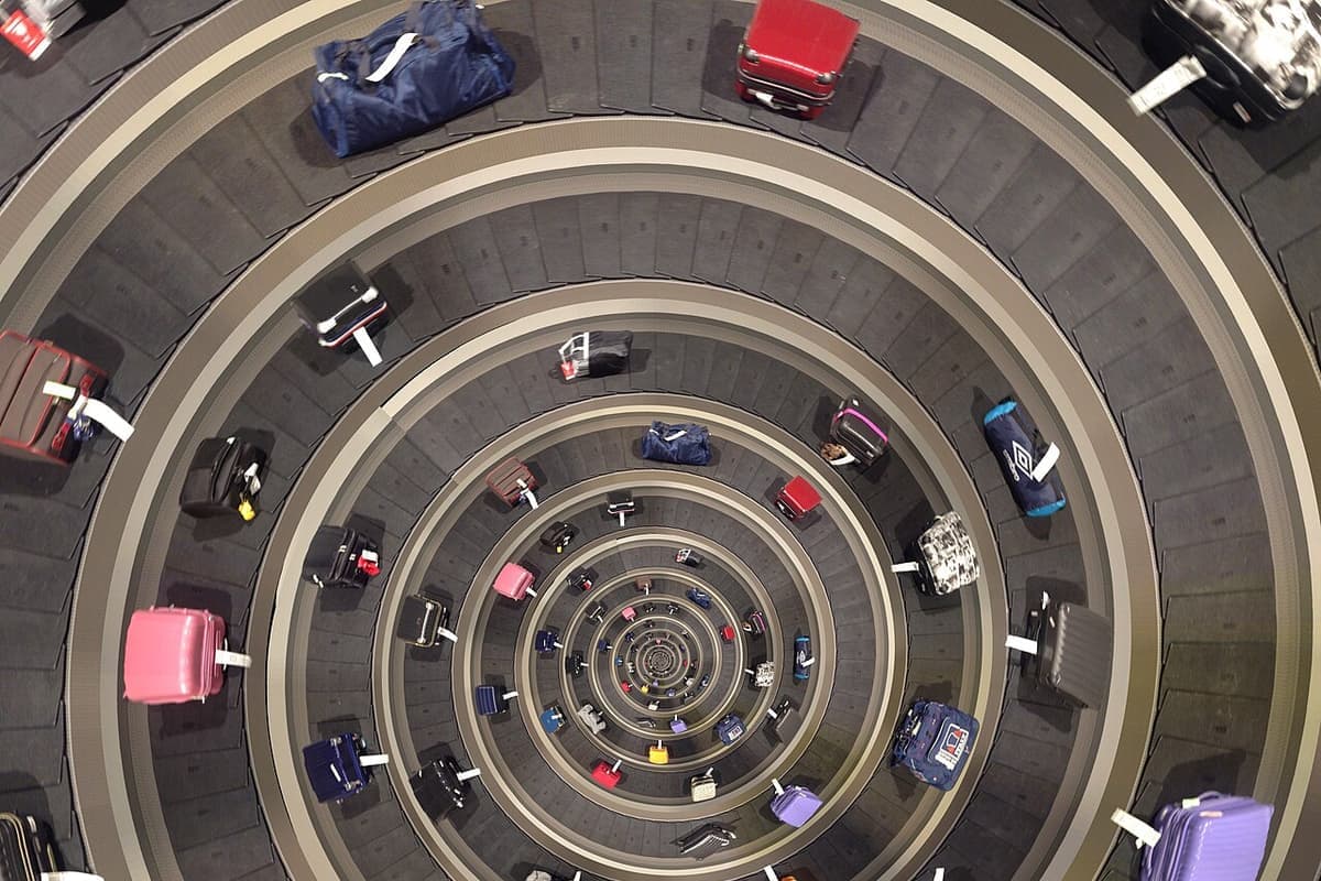 Suitcases circling a spiral baggage claim belt seen from above